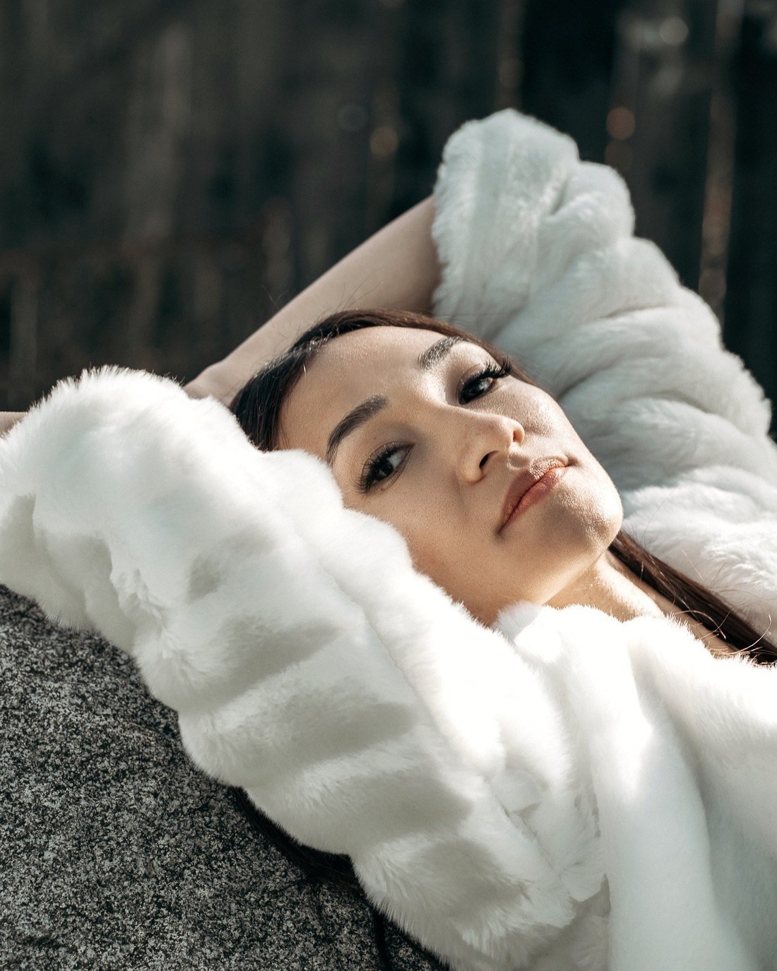 Mona Hassan resting, wrapped in white fur